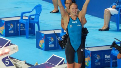 Sarah sträcker upp händerna över huvudet.