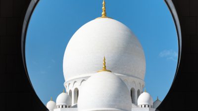 En stor vit moské med en blå himmel bakom.