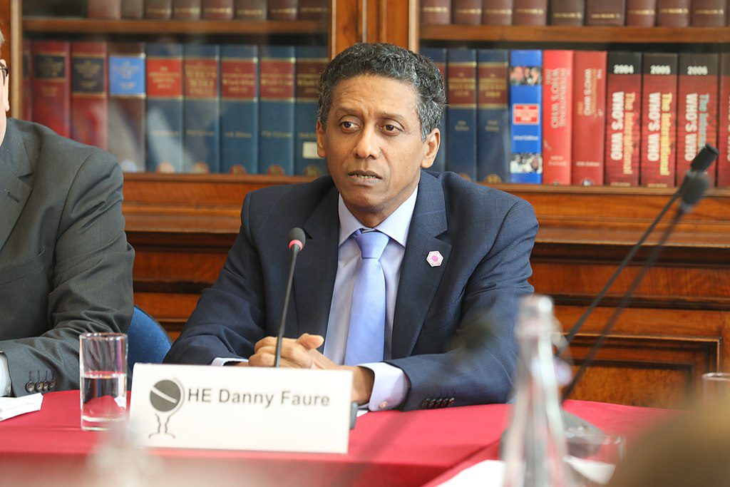 Bild på Seychellernas president Danny Faure. Han sitter i en talarstol och har en mikrofon framför sig.