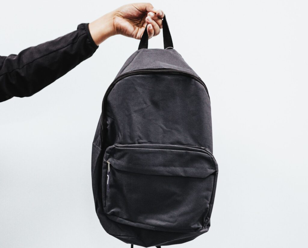 En hand som håller i en ryggsäck